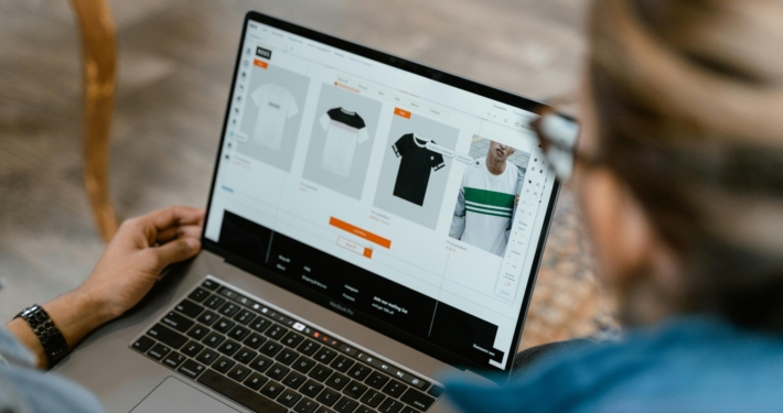 Persona che osserva un laptop, usufruendo di servizi premium di UX/UI per eCommerce